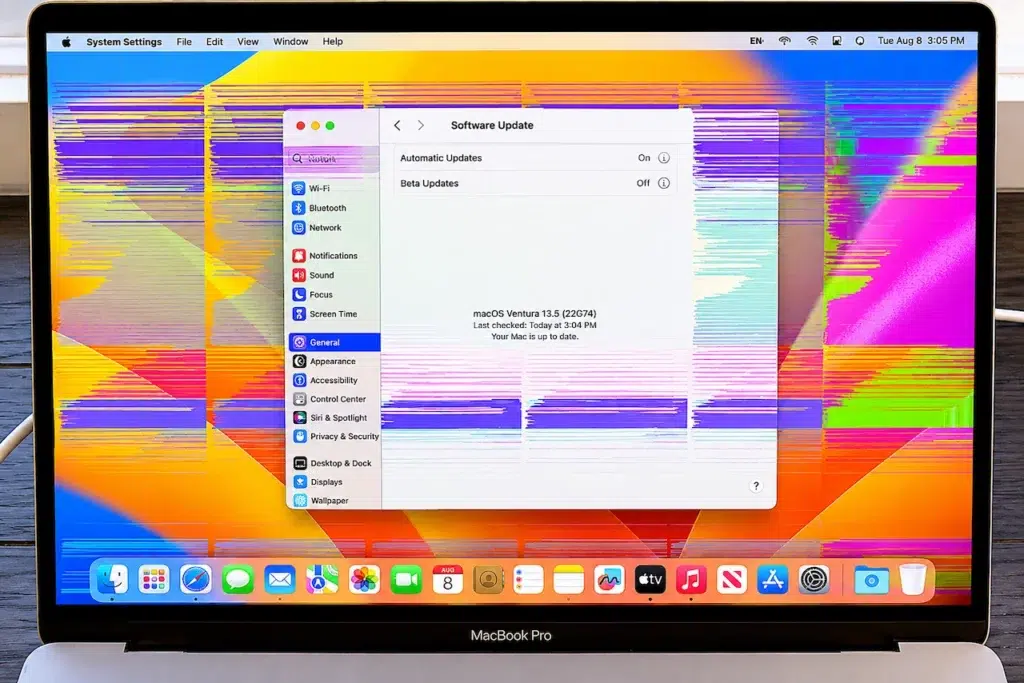 Écran de MacBook Pro affichant des artefacts vidéo colorés et des bandes horizontales.