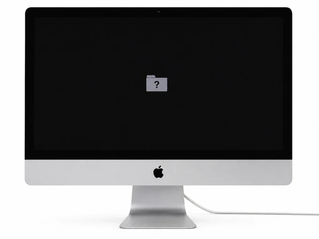 iMac 21 pouces affichant un dossier avec point d’interrogation au démarrage, signe possible d’un disque de démarrage ou SSD non détecté.